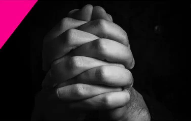 Un par de manos entrelazadas en oración, en blanco y negro